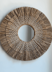 Espejo circular con anillos blancos de fibras naturales.